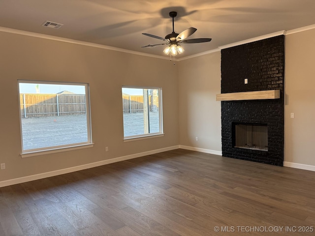 unfurnished living room with ornamental molding, a healthy amount of sunlight, dark wood-type flooring, and a fireplace