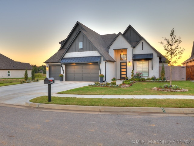 modern inspired farmhouse with a yard and a garage