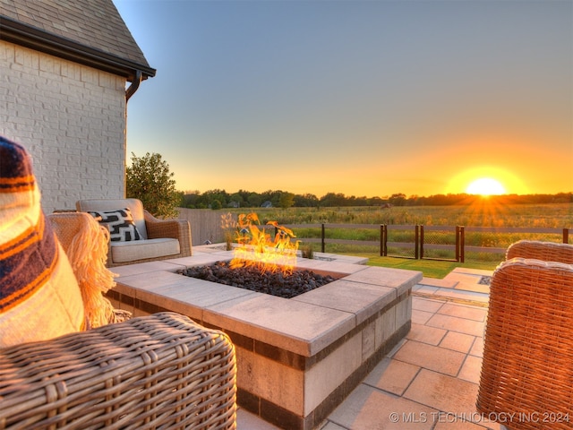 patio terrace at dusk with a rural view and a fire pit