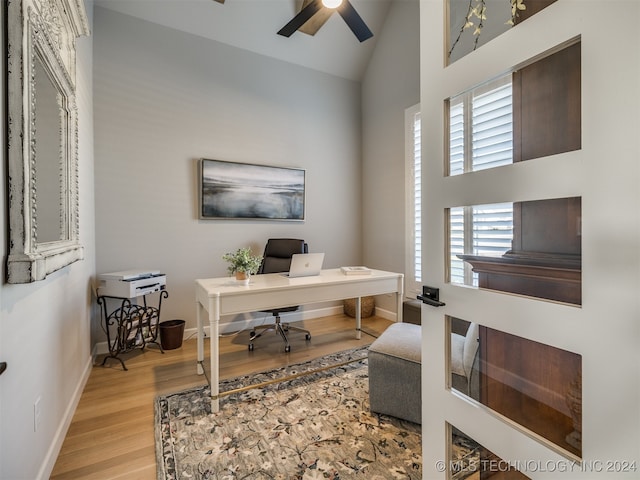 home office with ceiling fan, light hardwood / wood-style flooring, and high vaulted ceiling