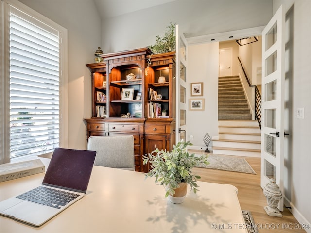 interior space with light hardwood / wood-style floors and vaulted ceiling