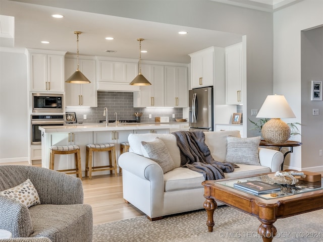 living room featuring light wood-type flooring and crown molding