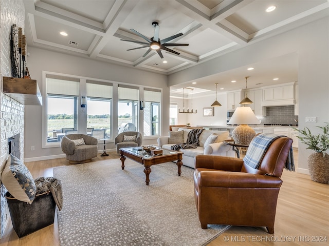 living room featuring coffered ceiling, light hardwood / wood-style flooring, and a healthy amount of sunlight