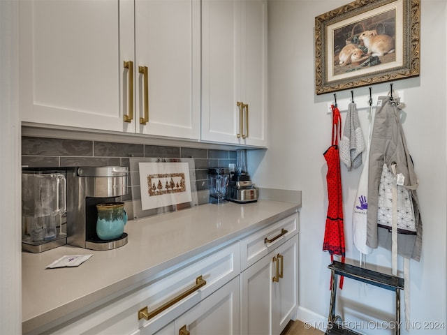 bar with white cabinetry and tasteful backsplash