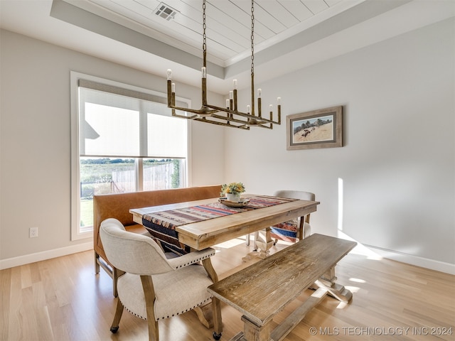 dining area featuring wood ceiling, light wood-type flooring, a tray ceiling, and a chandelier