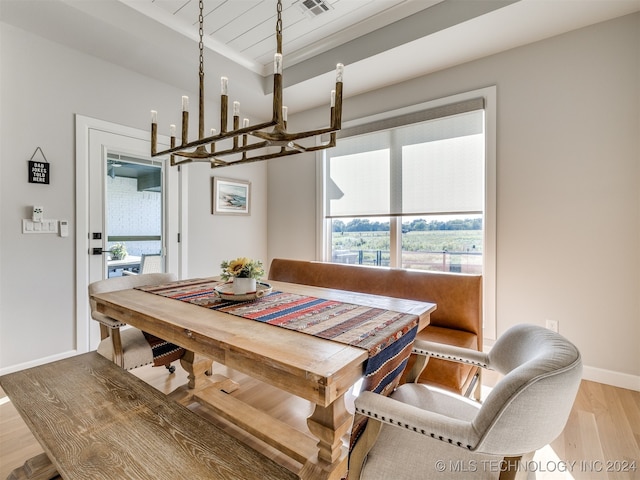 dining space with ornamental molding, a notable chandelier, wood ceiling, and light hardwood / wood-style floors