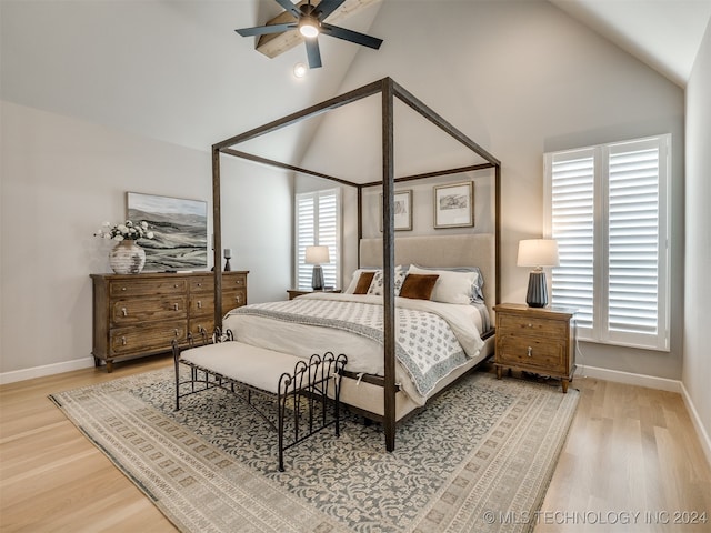 bedroom with ceiling fan, hardwood / wood-style flooring, multiple windows, and high vaulted ceiling