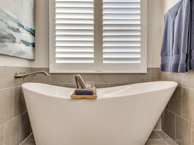 bathroom with a bathtub and tile walls