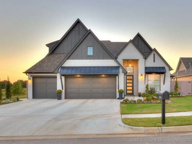 view of front of home with a garage and a lawn