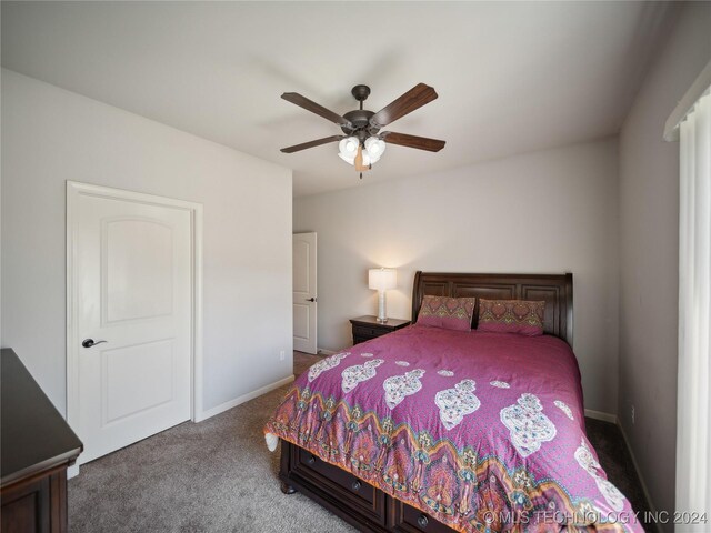 carpeted bedroom with a ceiling fan and baseboards