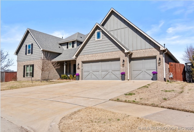 view of front facade with fence, board and batten siding, concrete driveway, roof with shingles, and brick siding