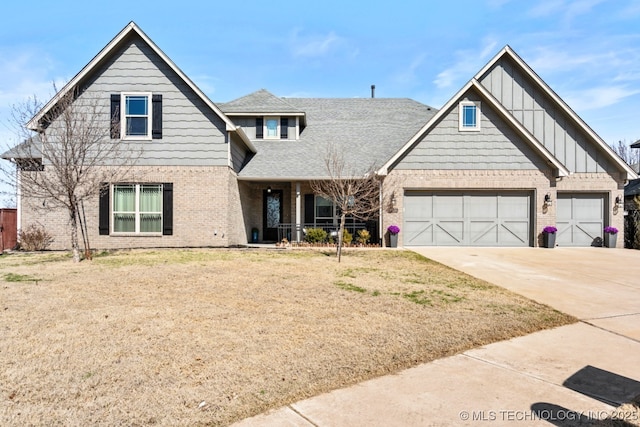 view of front facade with board and batten siding, concrete driveway, a front yard, roof with shingles, and brick siding