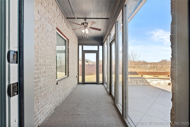 unfurnished sunroom featuring a wealth of natural light and a ceiling fan