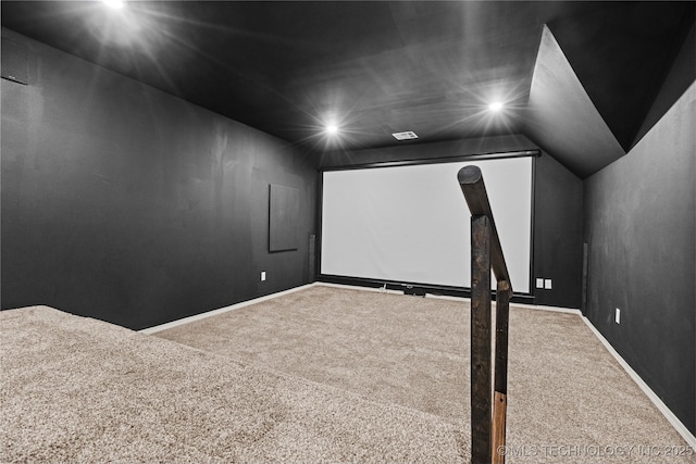 carpeted home theater room featuring baseboards and vaulted ceiling