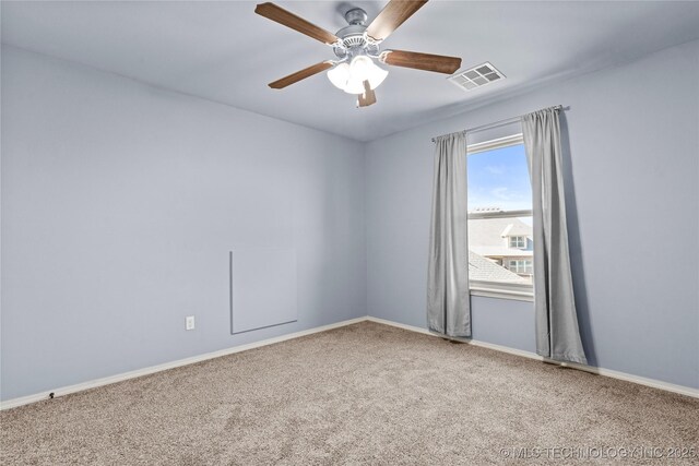 carpeted spare room featuring a ceiling fan, baseboards, and visible vents