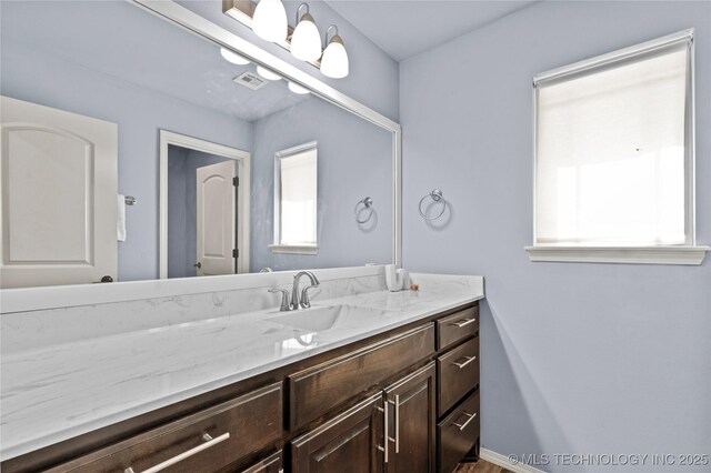 bathroom featuring visible vents, vanity, and baseboards