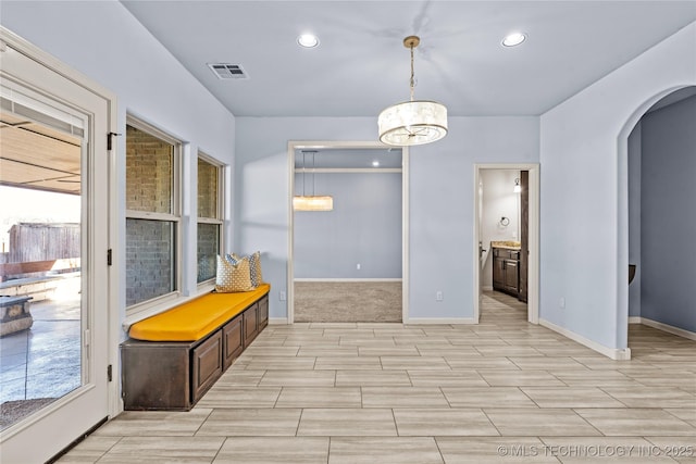 interior space featuring recessed lighting, visible vents, arched walkways, and baseboards