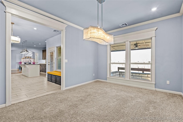 spare room featuring visible vents, light colored carpet, and crown molding