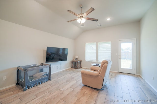 living room with ceiling fan, lofted ceiling, and light hardwood / wood-style floors