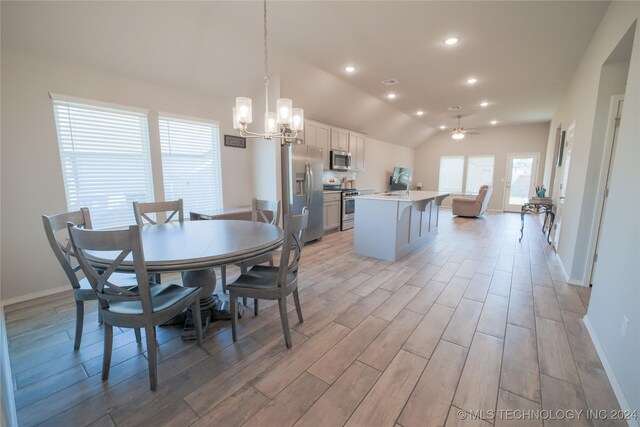 dining room with sink, a notable chandelier, and vaulted ceiling