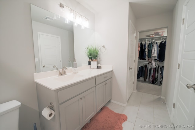 bathroom featuring toilet, vanity, and tile patterned flooring