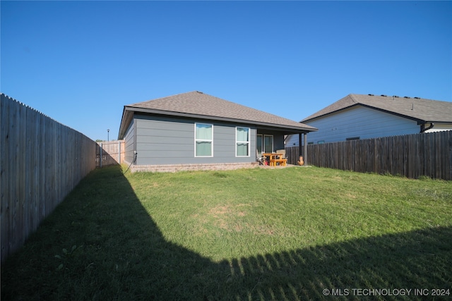 rear view of house with a yard