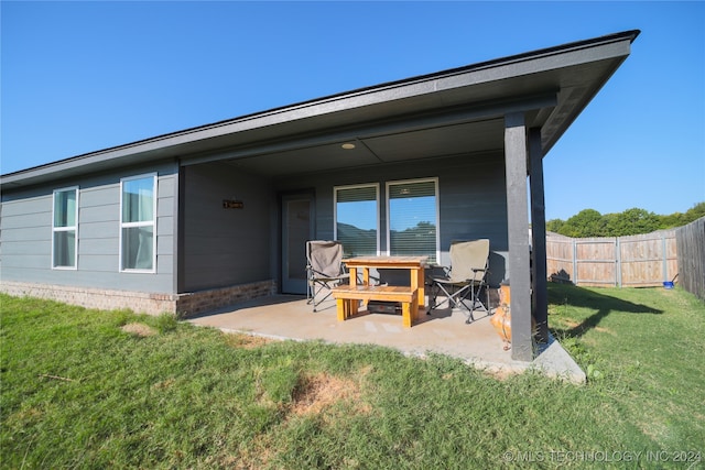 rear view of house with a yard and a patio