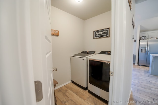 washroom with separate washer and dryer and light hardwood / wood-style floors