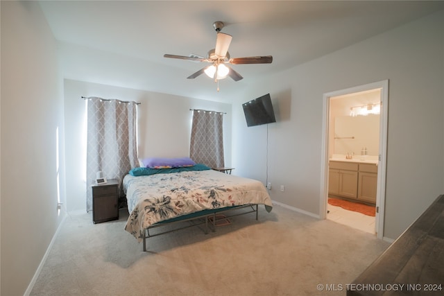 bedroom with ceiling fan, light colored carpet, and ensuite bathroom