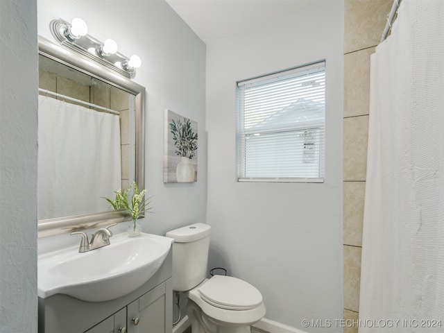 bathroom featuring vanity, curtained shower, and toilet