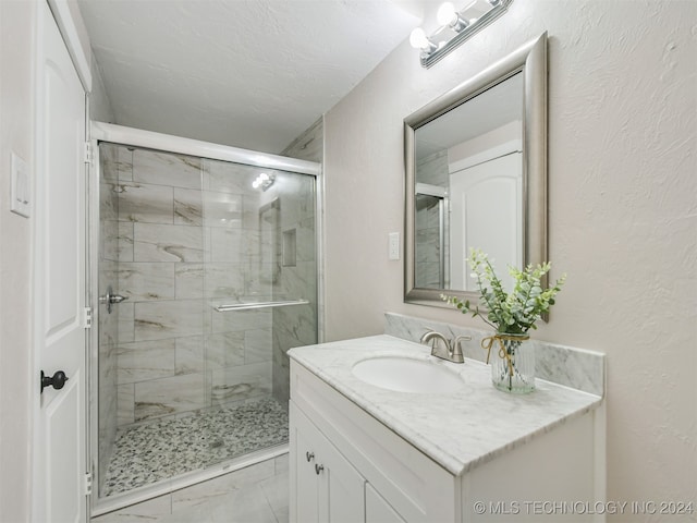 bathroom featuring vanity, a textured ceiling, and walk in shower