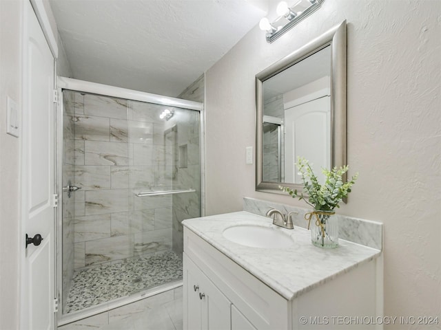 509 G St SW, Ardmore, OK 73401 - bathroom featuring vanity, a textured wall, a shower stall, and marble finish floor