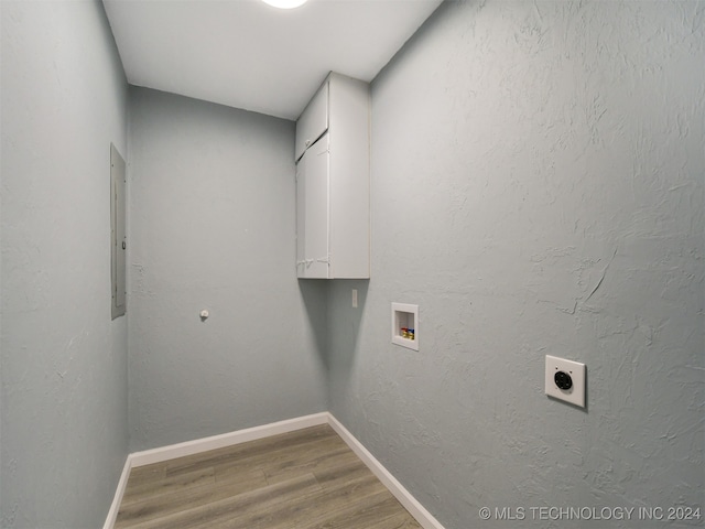 laundry room featuring wood-type flooring, cabinets, electric panel, hookup for a washing machine, and electric dryer hookup