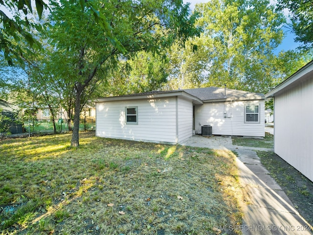 rear view of house with a yard and central AC unit