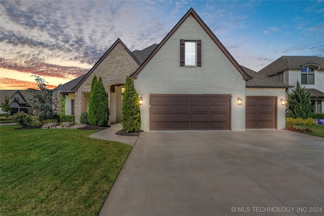 french provincial home with a yard and a garage