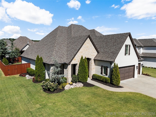 french country inspired facade with a front yard and a garage