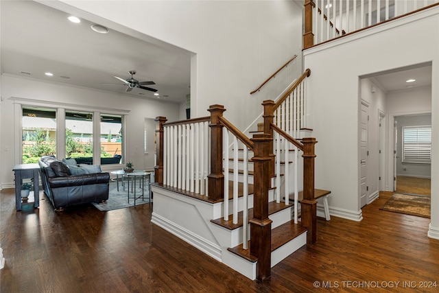 staircase with ornamental molding, hardwood / wood-style flooring, and ceiling fan