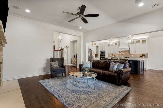 living room featuring dark wood-type flooring, crown molding, and ceiling fan