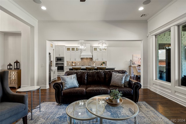 living room with an inviting chandelier, ornamental molding, and dark hardwood / wood-style flooring