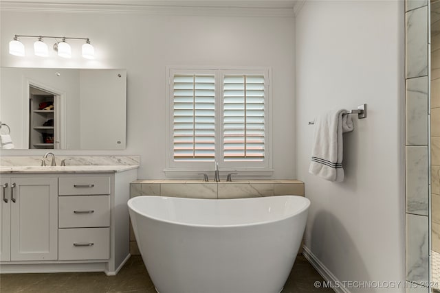 bathroom featuring vanity, ornamental molding, a tub, and tile patterned flooring