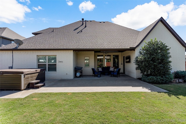 rear view of house featuring a hot tub, a patio area, a yard, and ceiling fan