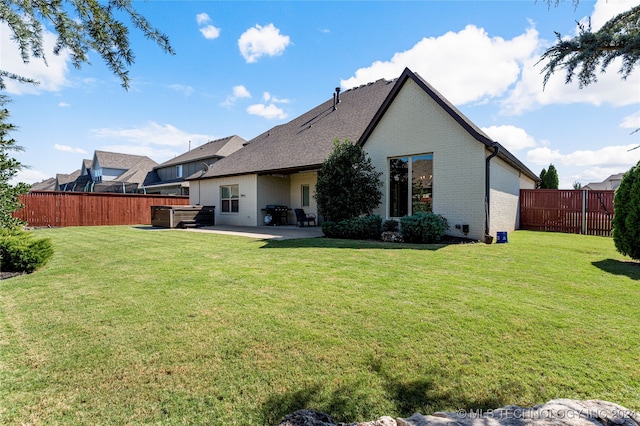 rear view of property featuring a patio and a lawn