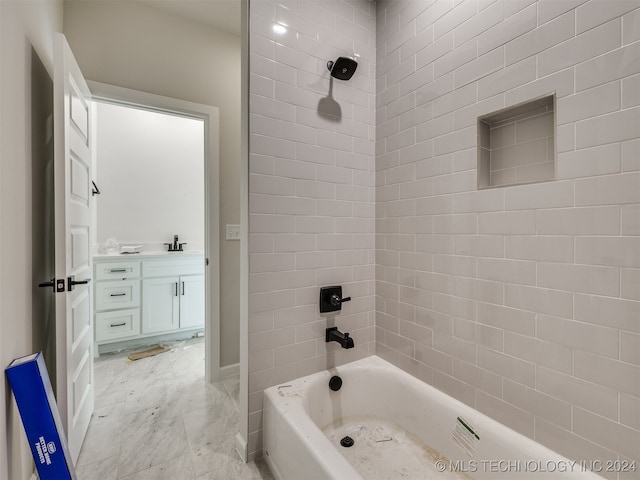 bathroom featuring tiled shower / bath and vanity