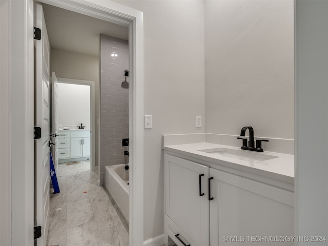 bathroom with tiled shower / bath and vanity