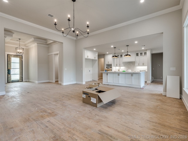 unfurnished living room with crown molding and light hardwood / wood-style floors