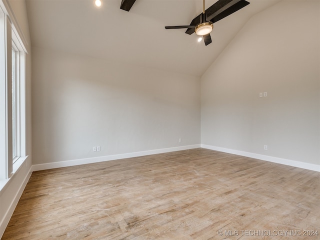 empty room featuring high vaulted ceiling, light hardwood / wood-style floors, and ceiling fan