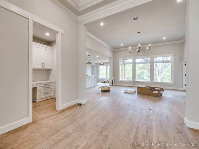 unfurnished living room with light hardwood / wood-style flooring, a wealth of natural light, and ornamental molding