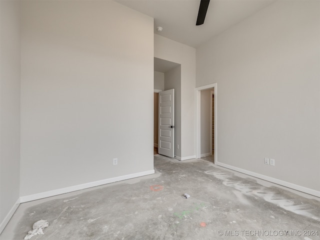 unfurnished room with ceiling fan and concrete flooring