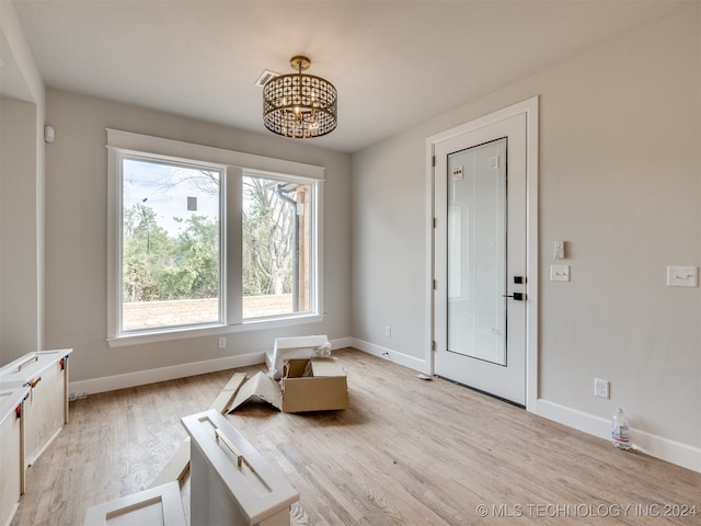 living area with light hardwood / wood-style flooring and a notable chandelier