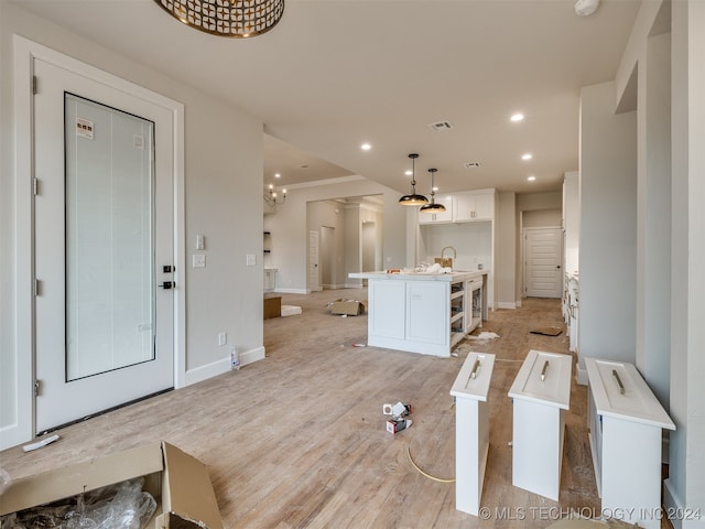 living room featuring light hardwood / wood-style floors, an inviting chandelier, and sink